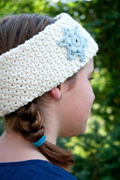 Girl with braids and white crochet headband with snowflake