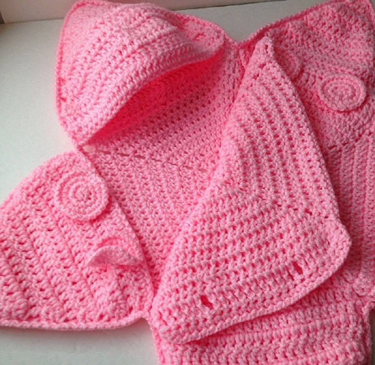 A baby pink crochet baby star costume with the front folded down and buttonholes for you to fasten the costume.