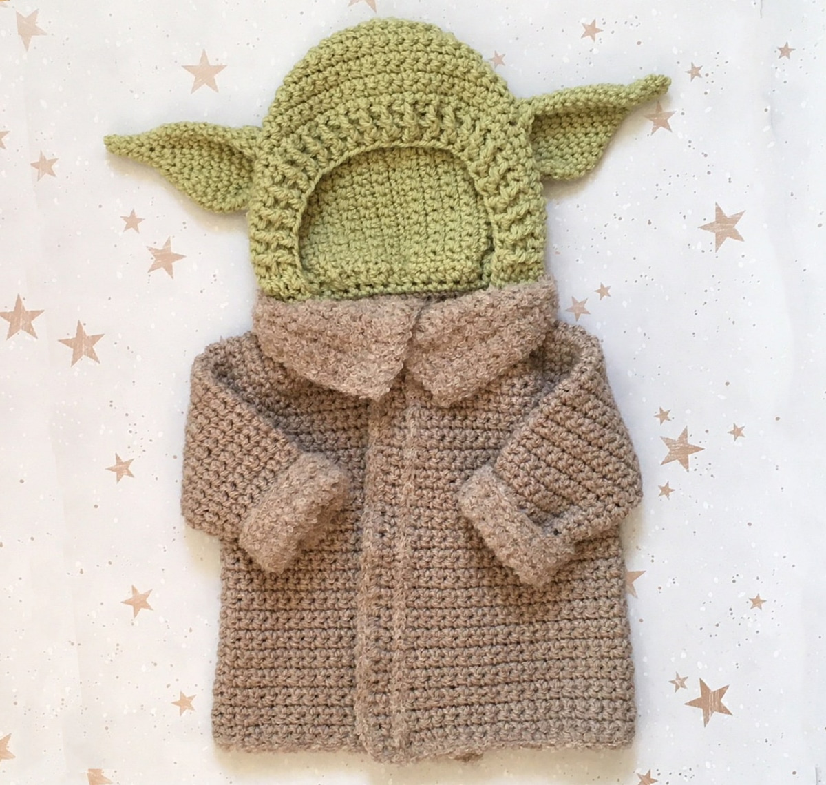 Crochet baby Yoda costume with a green crochet hat with ears either side and long brown robe with a small collar.