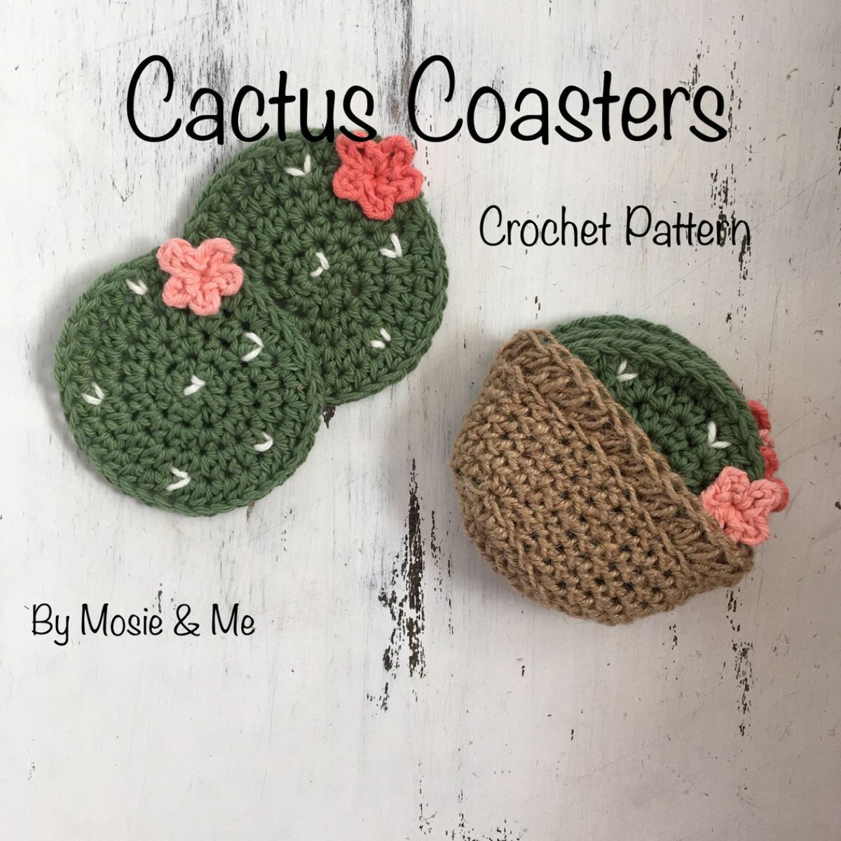 Green cactus style crochet coasters with white spots and pink flowers on top next to a brown crochet coaster holder.
