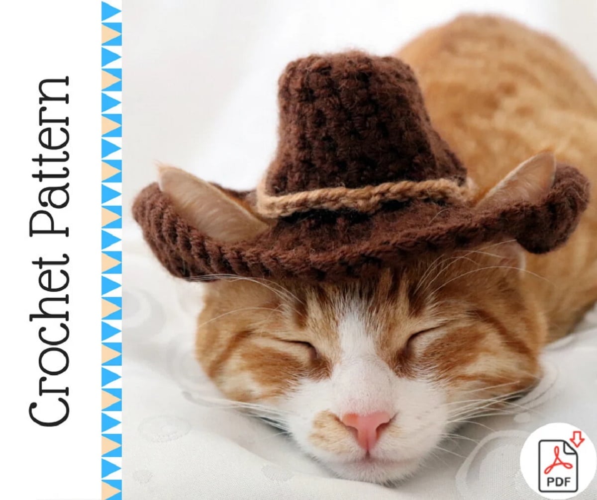  Orange and white cat asleep on a white blanket wearing a small brown crochet cowboy hat.