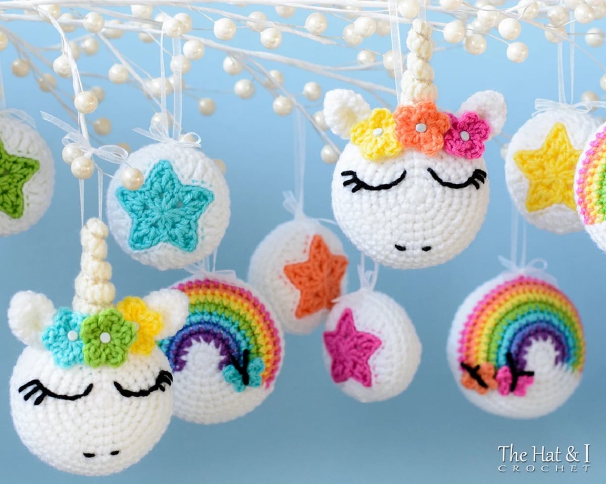 White round crochet ornaments with unicorn faces and horns on them with small flowers around the horns.