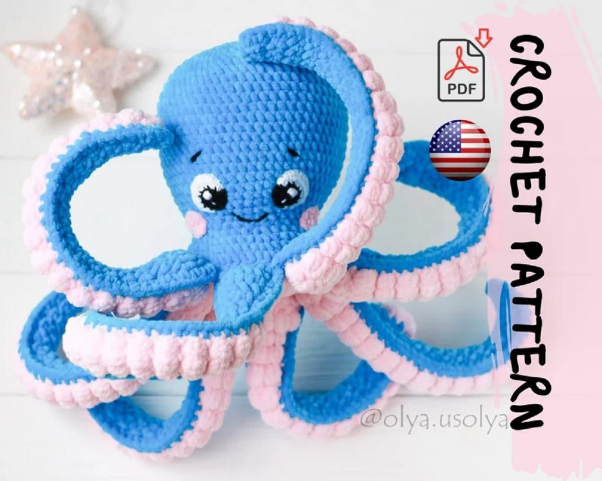 Large blue smiling crochet octopus with pale pink textured tentacles that are raised for you to see their underneath.
