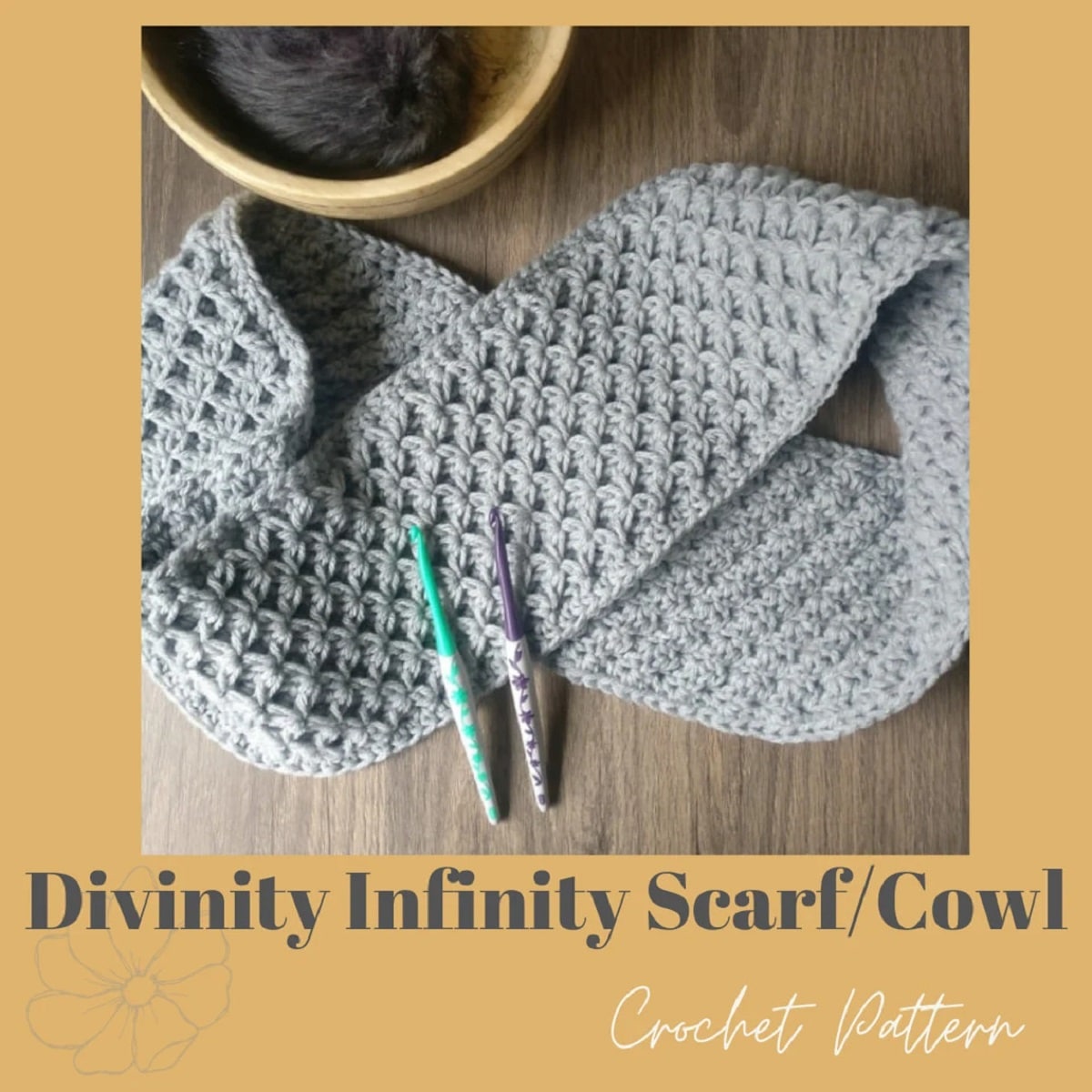 Light gray crochet infinity scarf with a tight waffle stitching folded on a wooden table next to a crochet hook and coffee cup.
