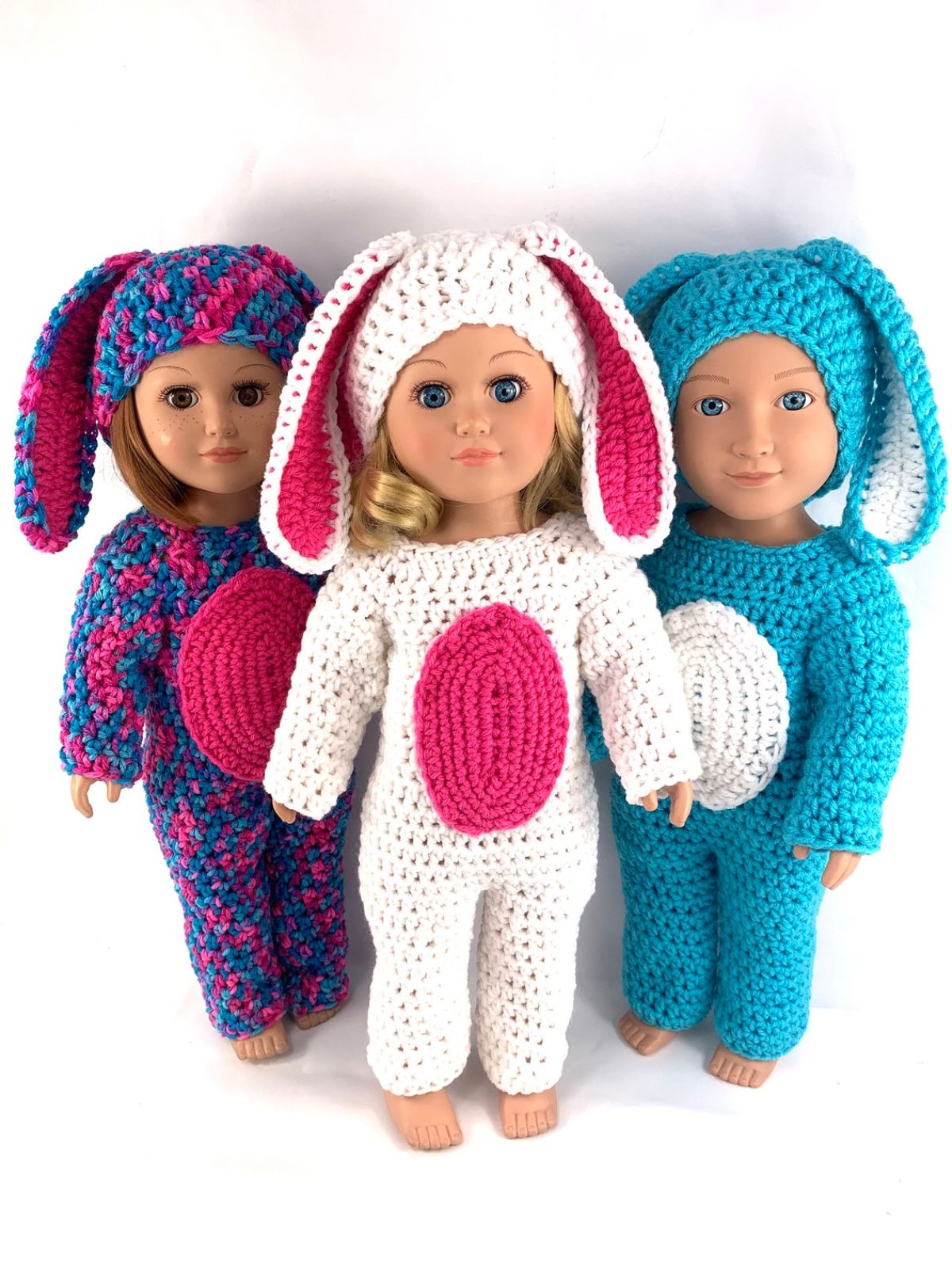 Three girl dolls wearing full length bunny outfits with matching hats with floppy bunny ears standing next to each other.