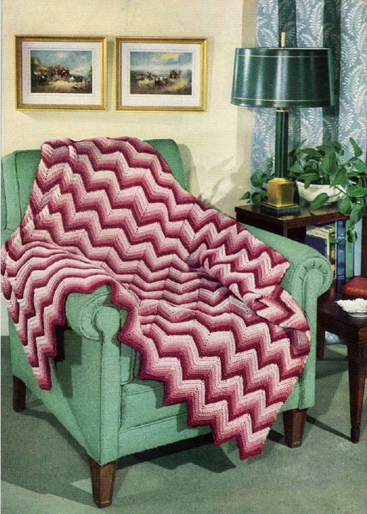Large purple and pink crochet zig zag striped blanket with a zig zag trim on the bottom draped over a green chair.