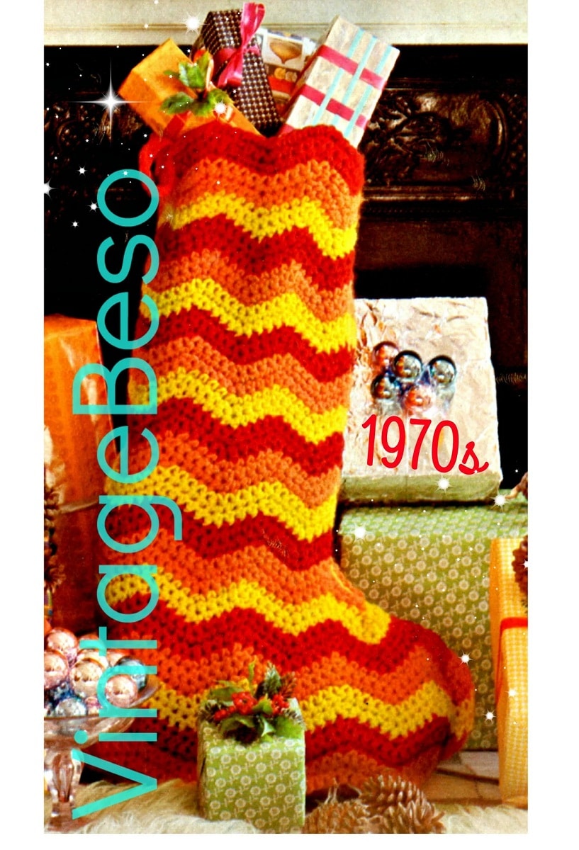 Oversized crochet Christmas stocking with a large red, orange, and yellow zig zag pattern and stuffed with wrapped gifts.