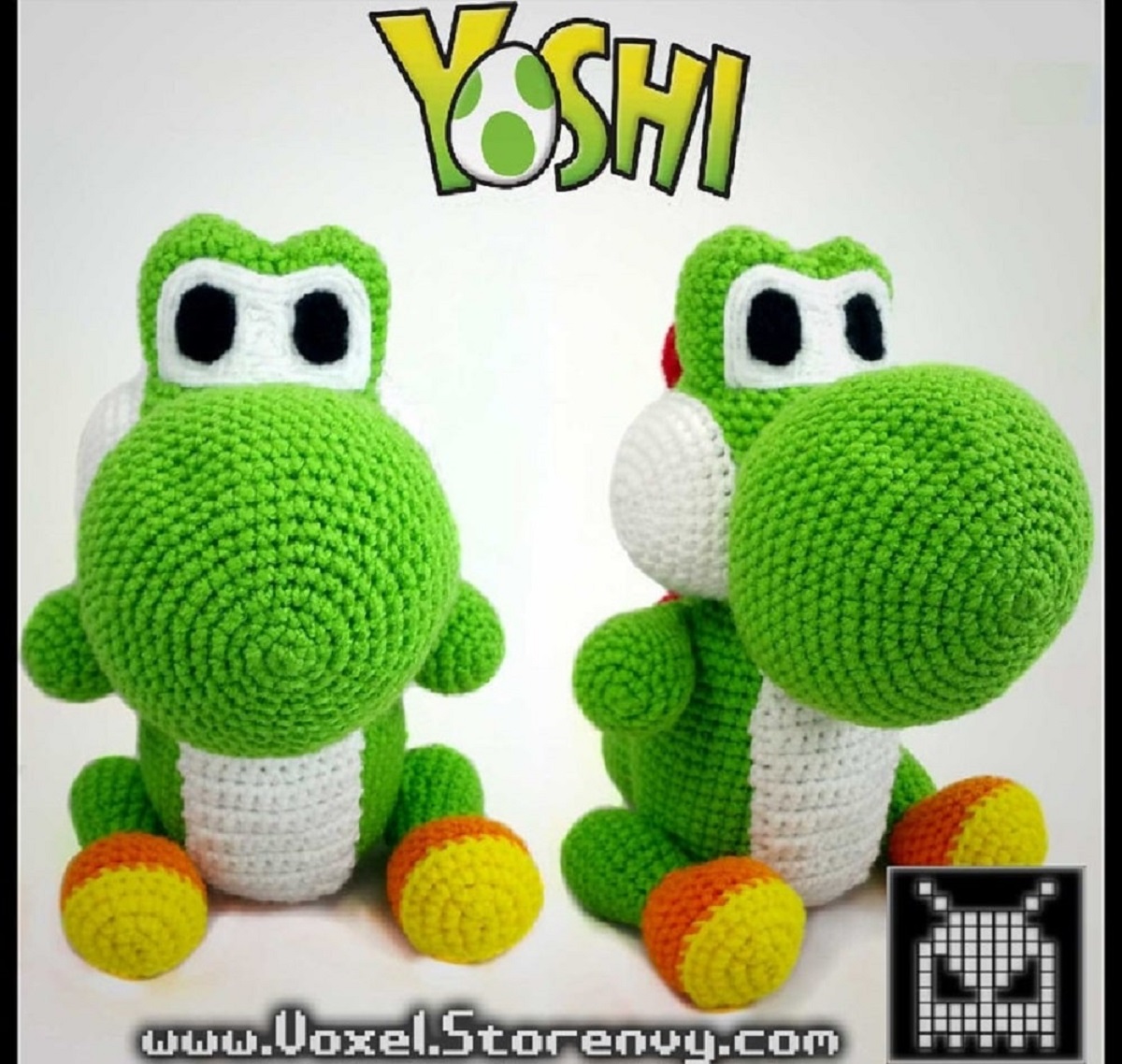 Two crochet green and white Yoshi’s sitting next to each other with large noses and small yellow and orange feet.