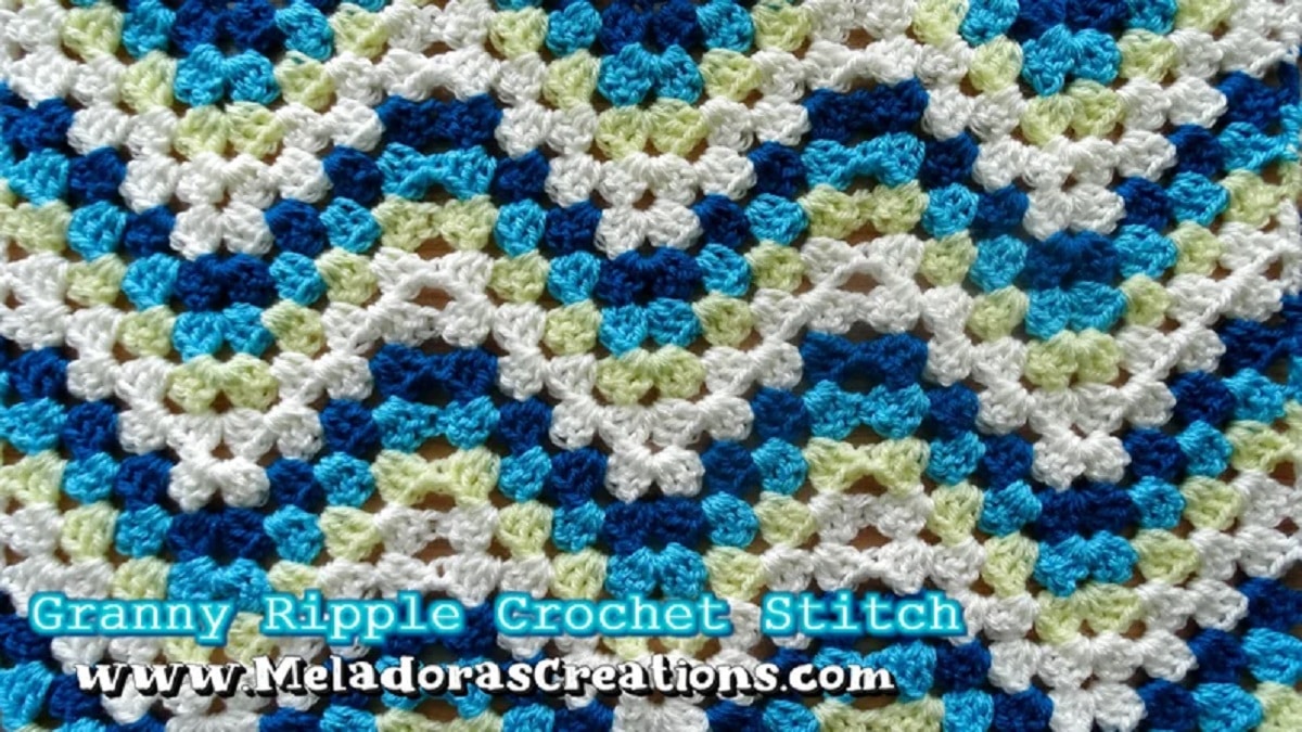 Dark blue, light blue, green, and cream zig-zag striped crochet blanket using a granny stitch.