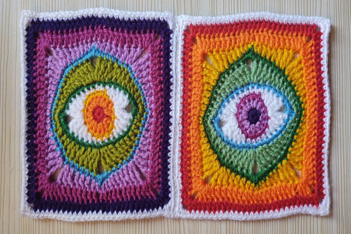 Two psychedelic crochet granny squares with eyes in the center using red, orange, green, blue, purple, pink, and white yarn.
