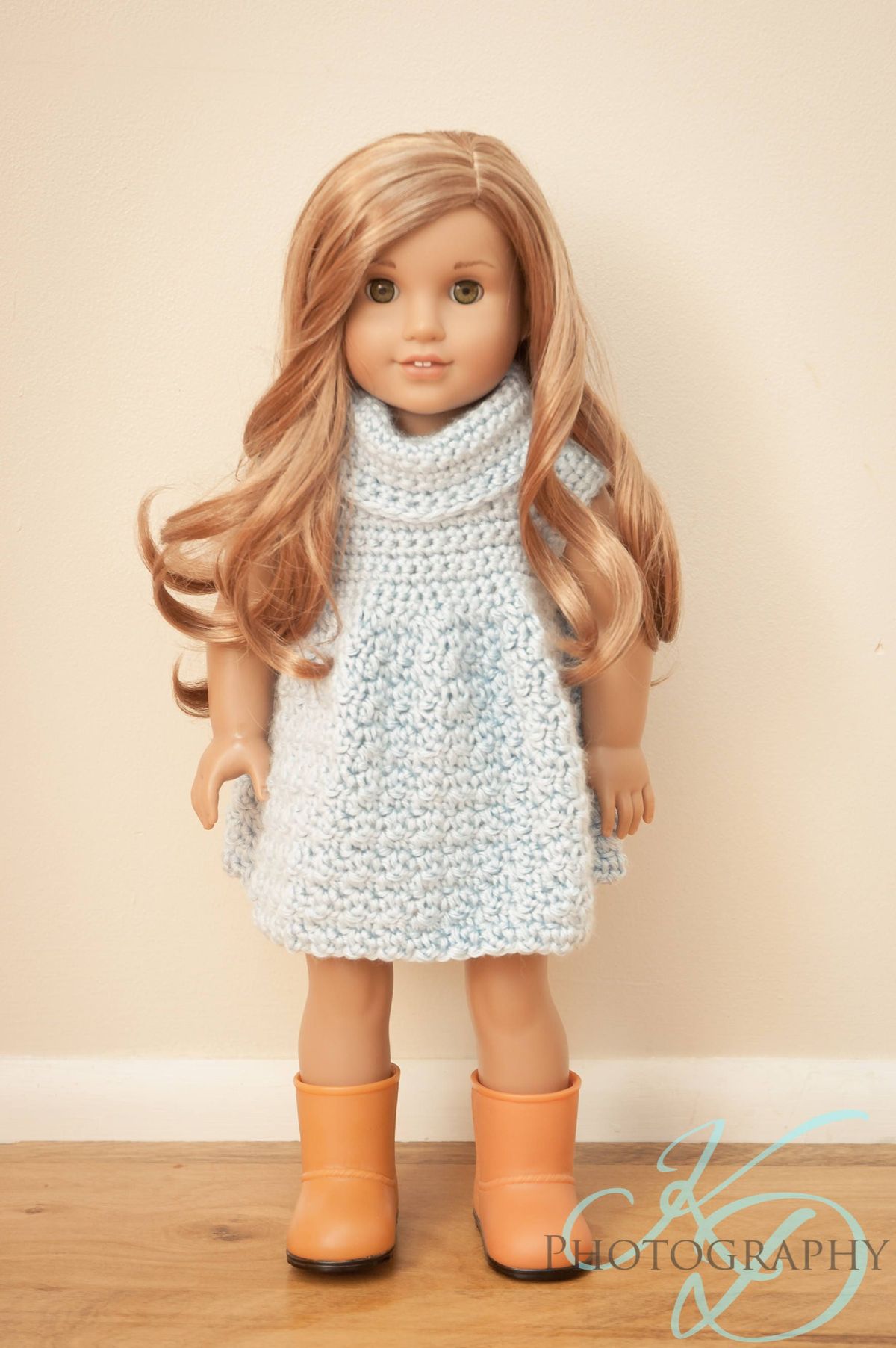 Blonde doll wearing a sleeveless crochet sweater dress with a high roll neck and peach boots.