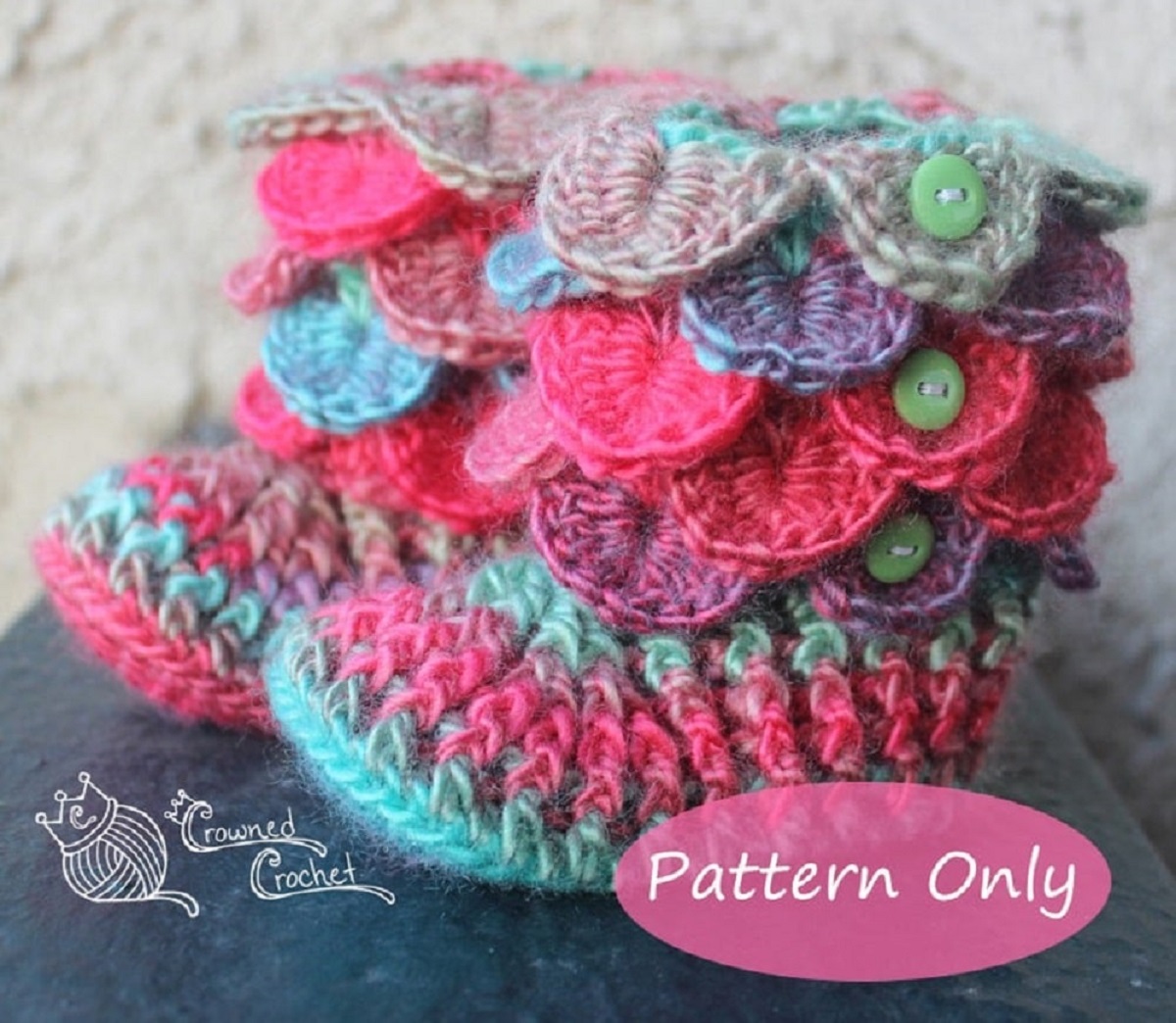 Multicolored baby booties with crochet fins from the ankle up to the top of the boot and green buttons down the side.