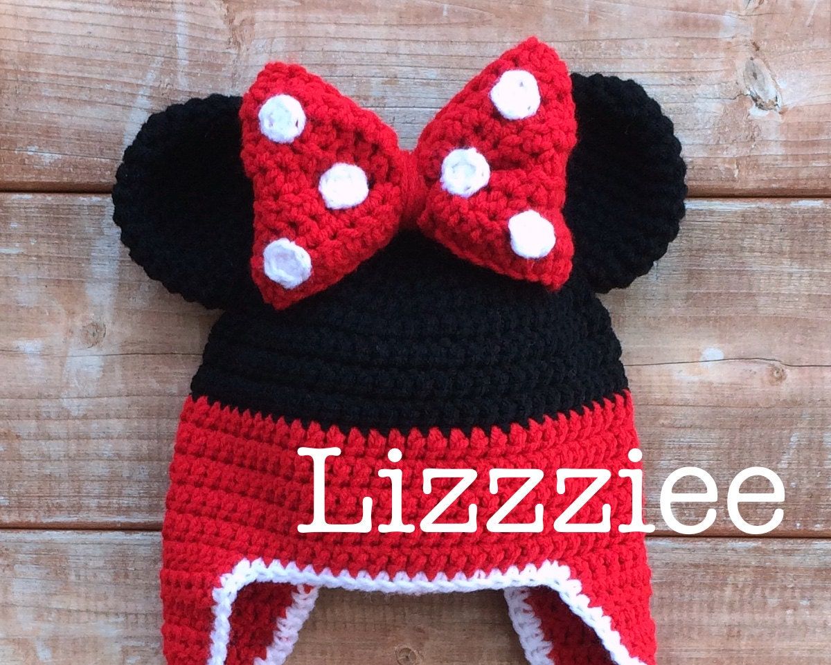Minnie Mouse style crochet beanie hat with a red and white spotty bow in the center and black mouse ears either side.