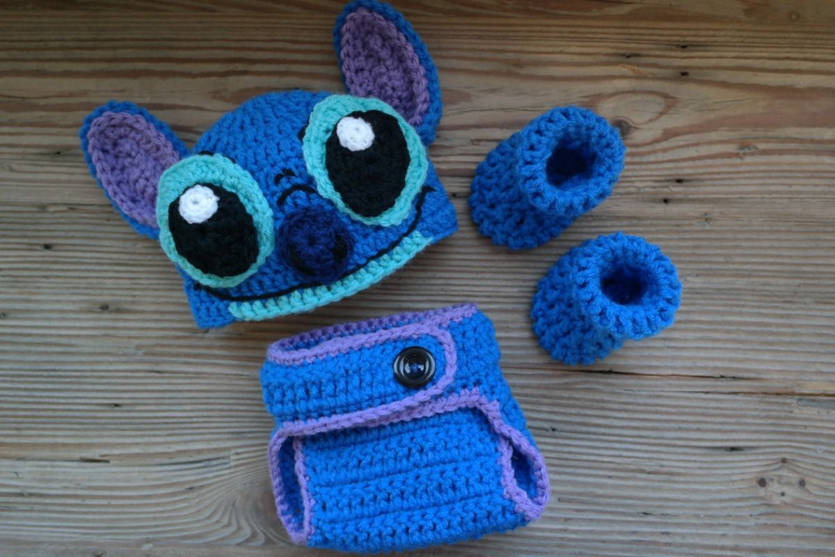 Crochet Stitch costume for babies with a beanie with Stitch’s face on, a blue crochet diaper and small blue booties.