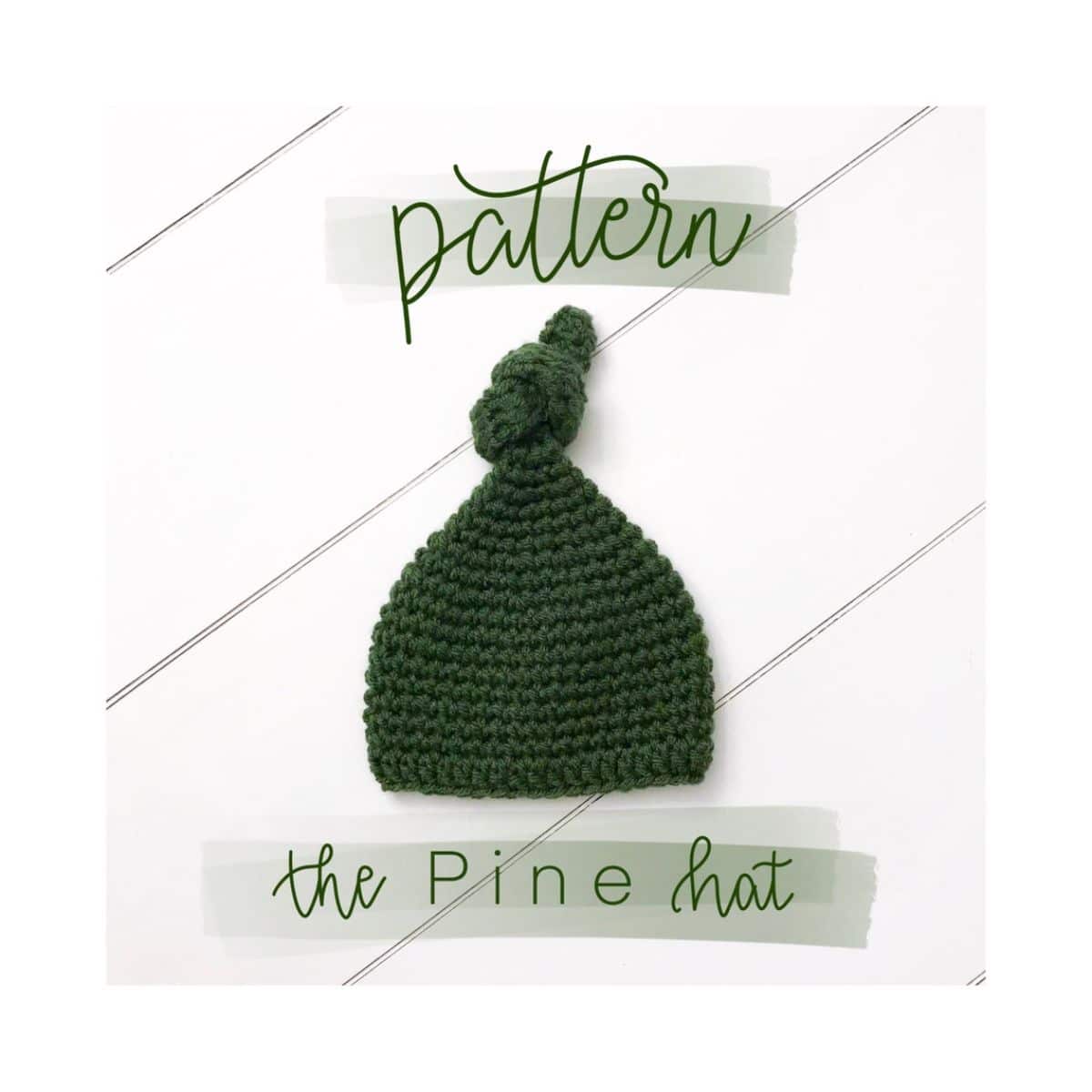 Green crochet beanie with a twisted knot at the top of the hat lying on a white wooden background.