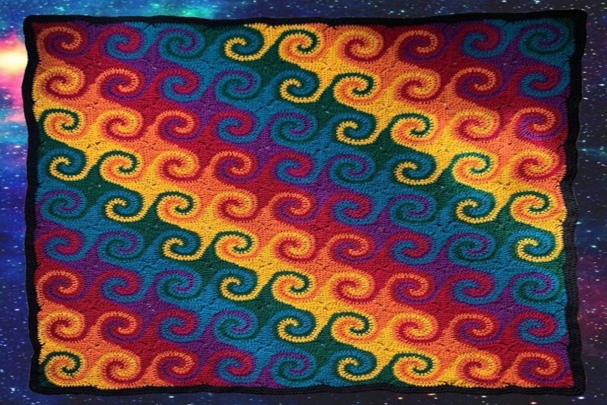 Rainbow colored diagonal striped crochet piece with swirls on each block of color and a black trim on all four sides.