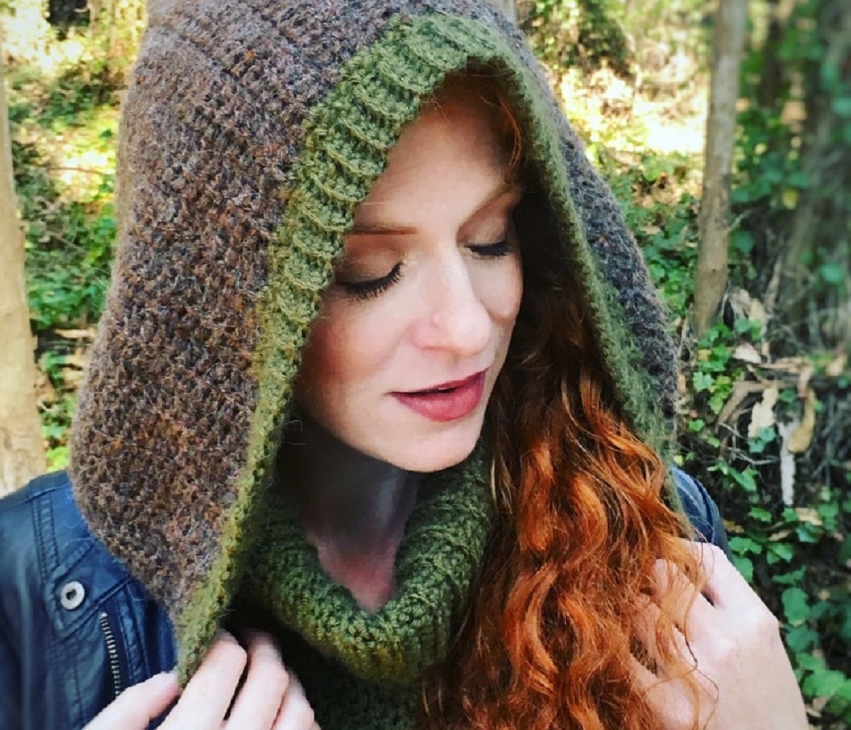 Redhead woman wearing a brown and green Robin Hood style hooded scarf.
