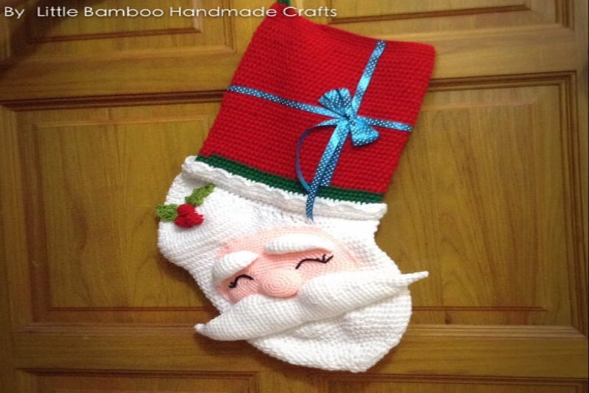 The classic design of a red knitted stocking with white fluffy banding across the top with a small red loop to hang the stocking. 