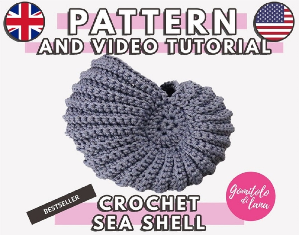 A gray crochet sea shell with an open top to act as a basket on a white background with writing around it for video tutorials.