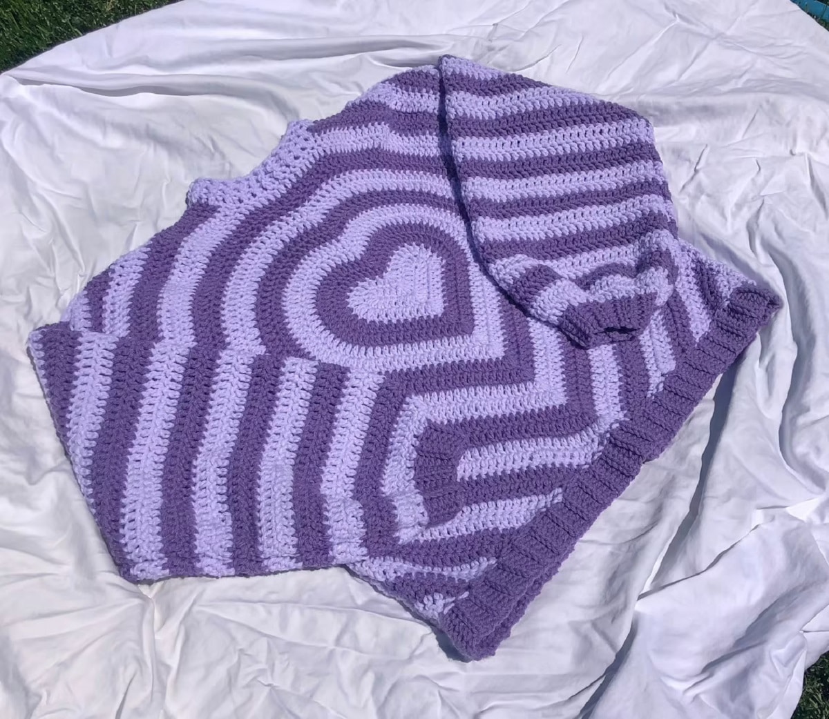 Light purple and dark purple striped crochet sweater with a purple heart in the center, long sleeves, and a round neckline.