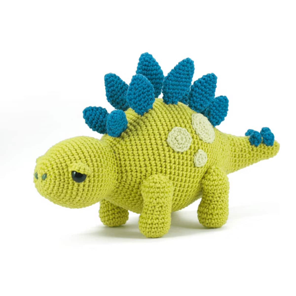 Green Stegosaurus with light green spots and dark blue spikes over its back standing on a white background.