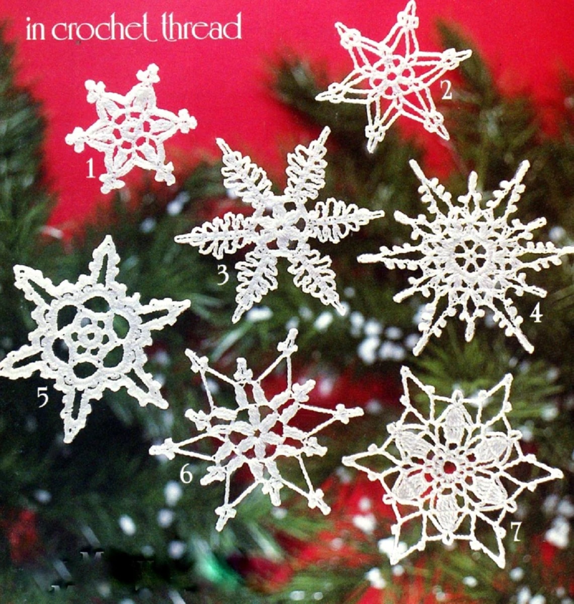 Several white vintage style crochet snowflakes in front of a blurry Christmas tree and red background.
