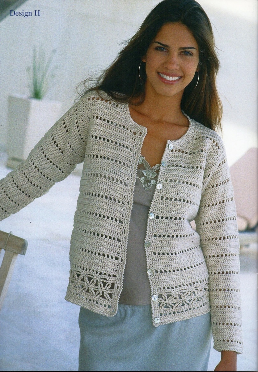 Dark haired woman wearing a white lacy crochet cardigan with small buttons down the center and a starfish pattern at the bottom.