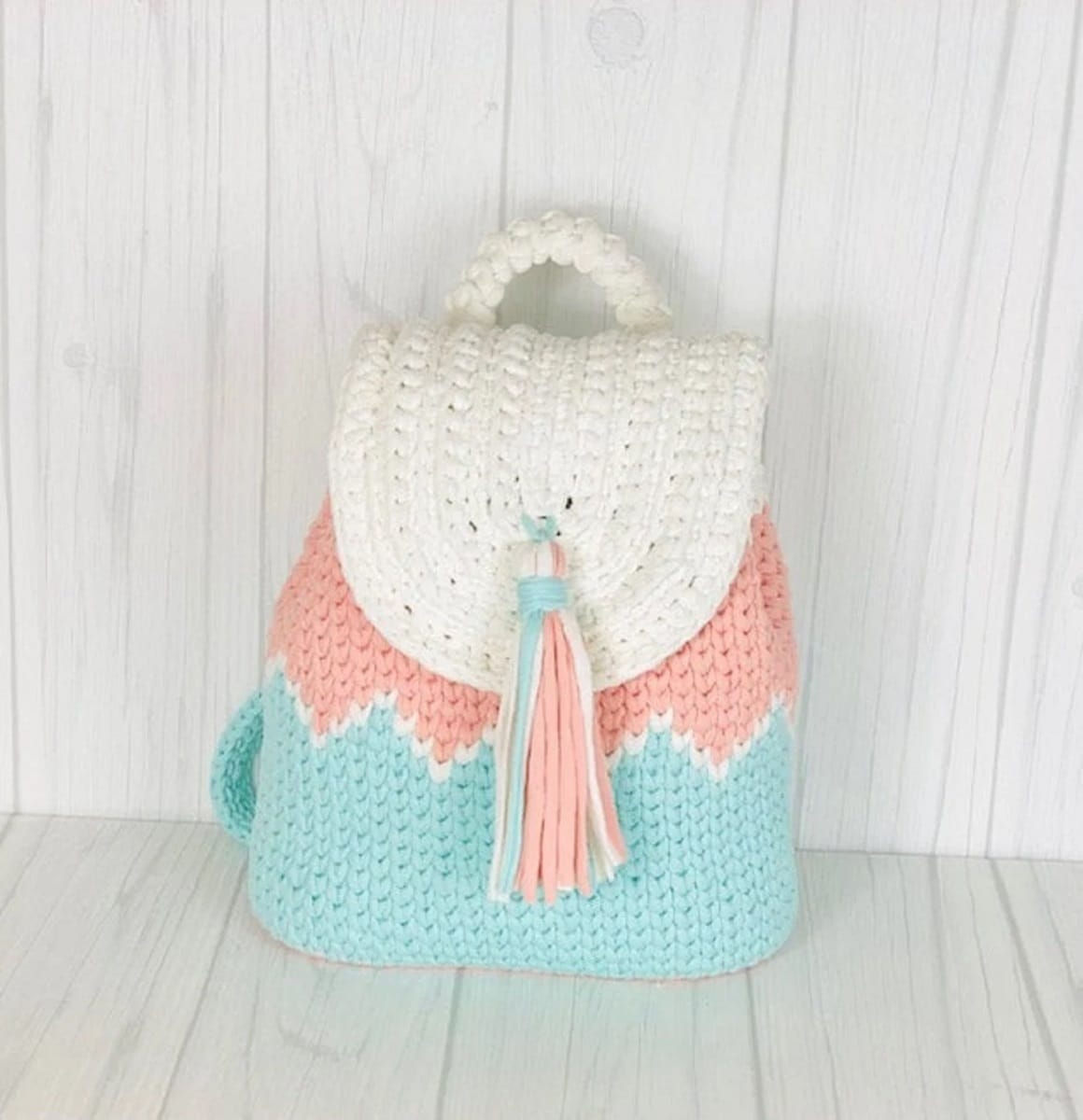 Blue and orange crochet zig zag back back with a cream flap over the top and long blue and orange tassel down the center. 