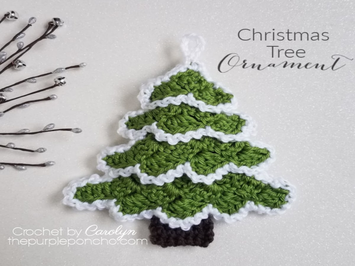 A green crochet Christmas tree with a white edge on each branch and a loop at the top to hang it.