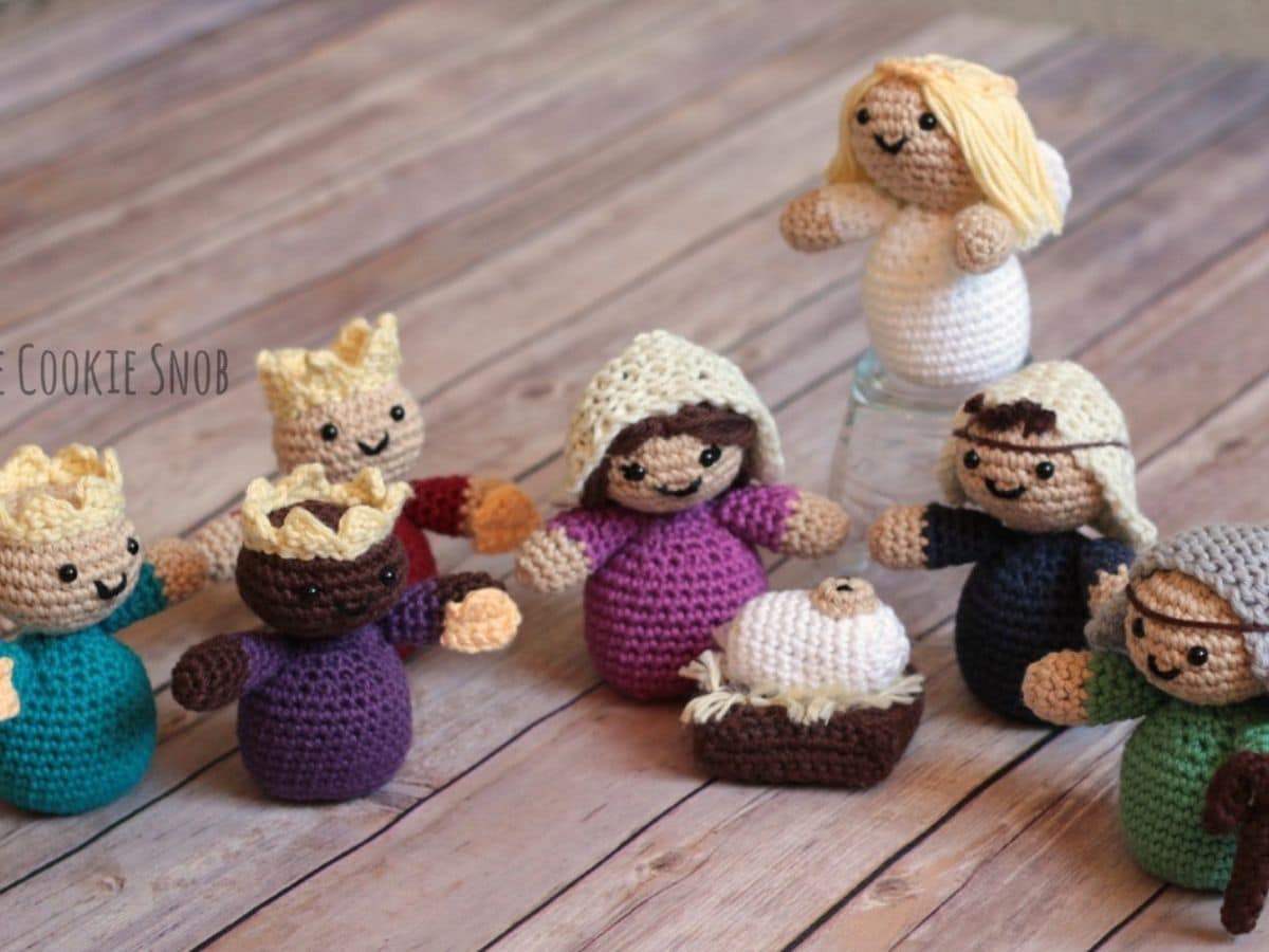 Small and round crochet nativity scene including Mary, Joseph, three kings, shepherds, the angel Gabriel, and a baby Jesus.
