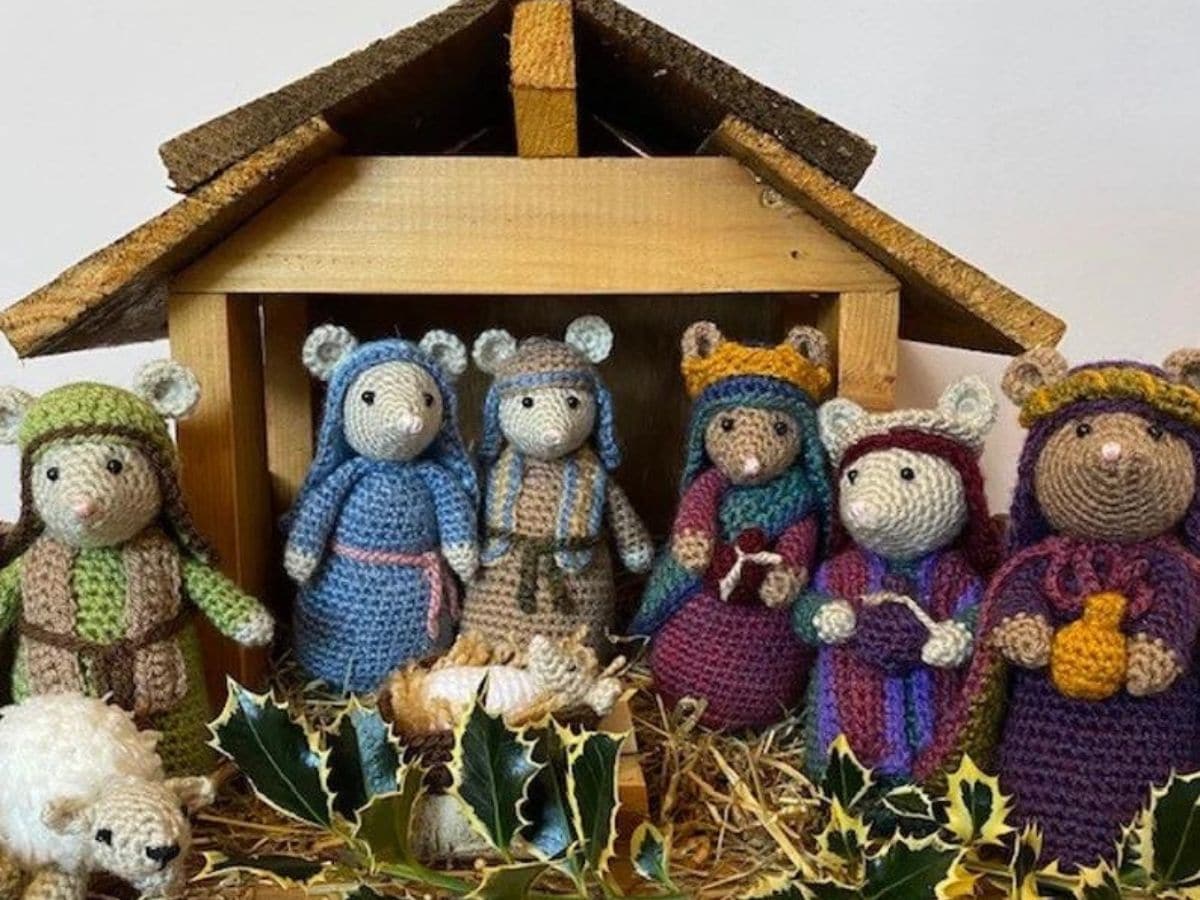 A wooden barn with a nativity scene in front of it using mice as the characters.
