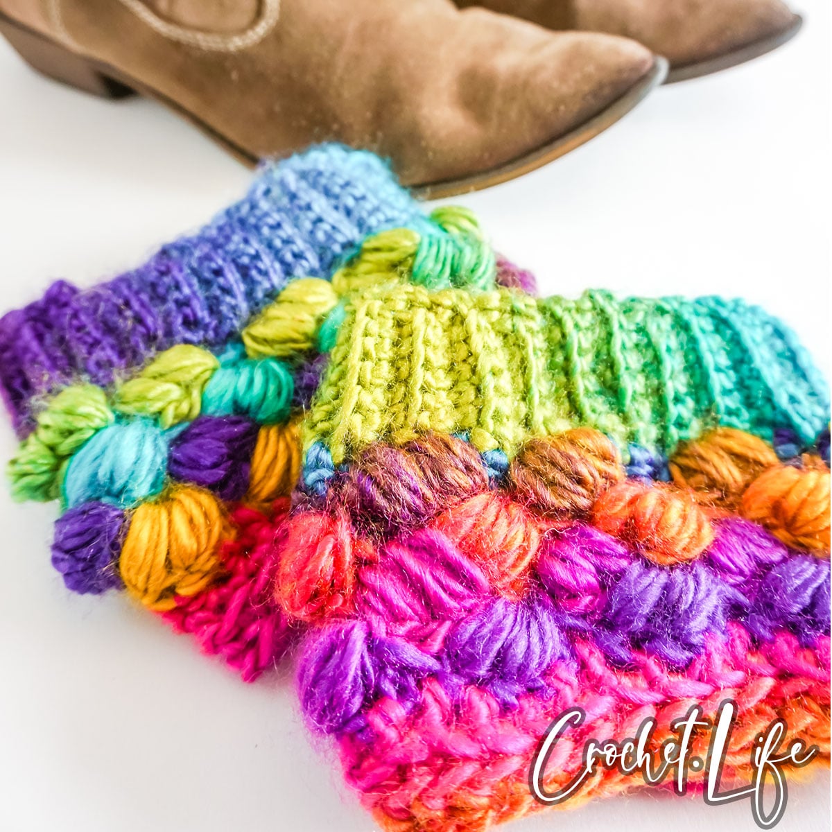 Multi-colored boot cuffs packed densely with different colored balls. Bright pink, purple, orange, yellow, and green make up the cuffs. 