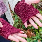 hands wearing fingerless mittens mad from a free crochet pattern