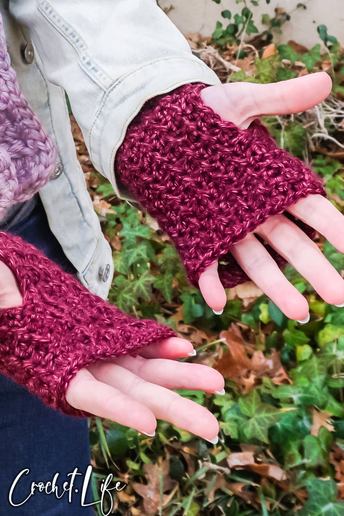 hands wearing fingerless mittens mad from a free crochet pattern 