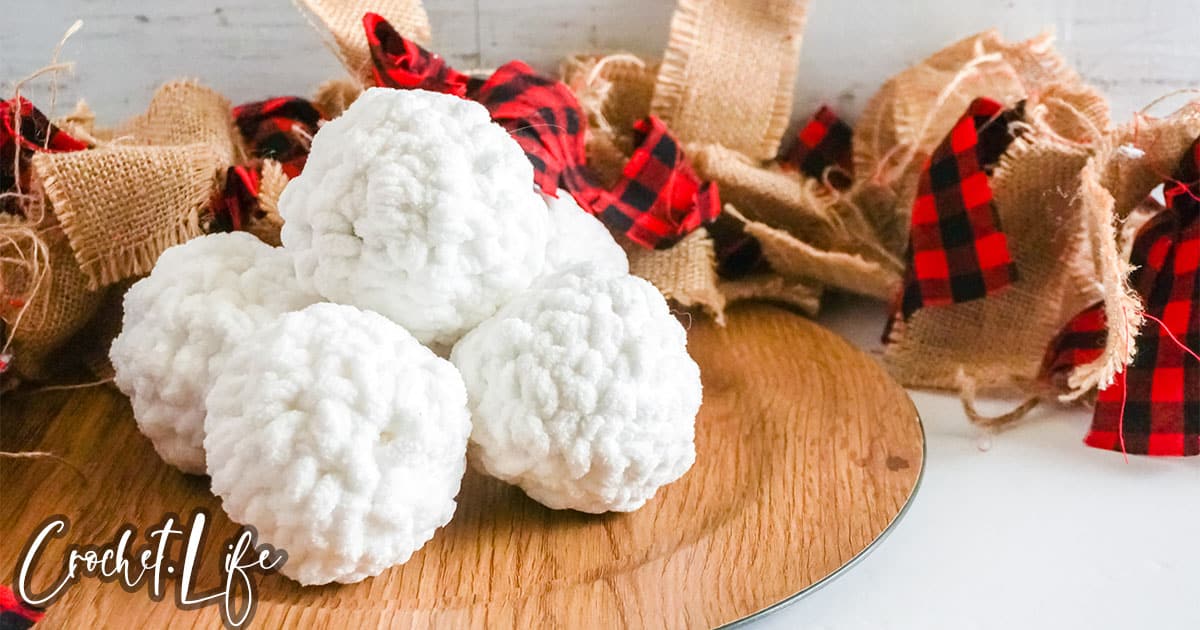 crocheted snow balls on a wood plate
