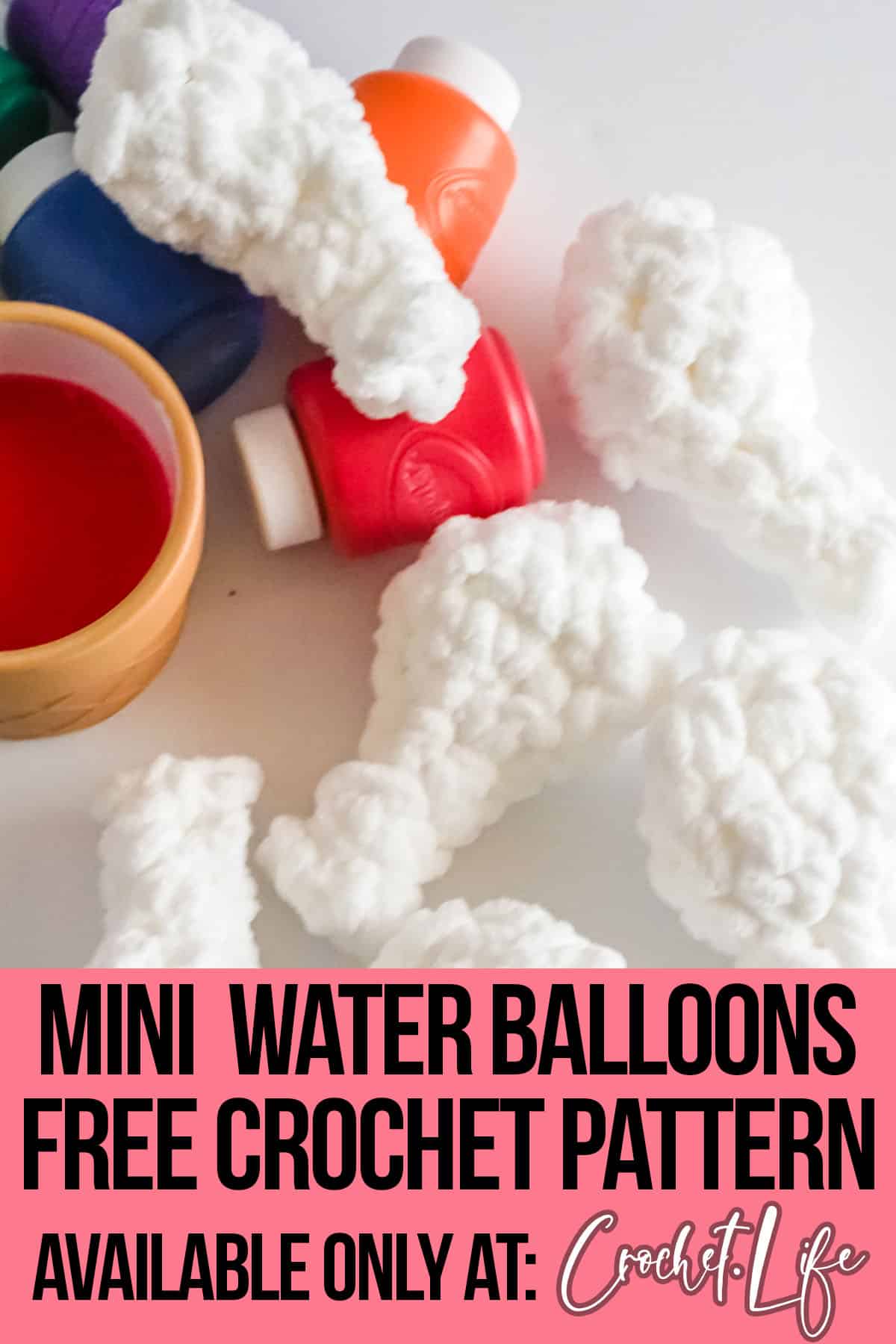 several crocheted mini water balloons on a table with finger paints in bottles with text which reads mini water balloons free crochet pattern